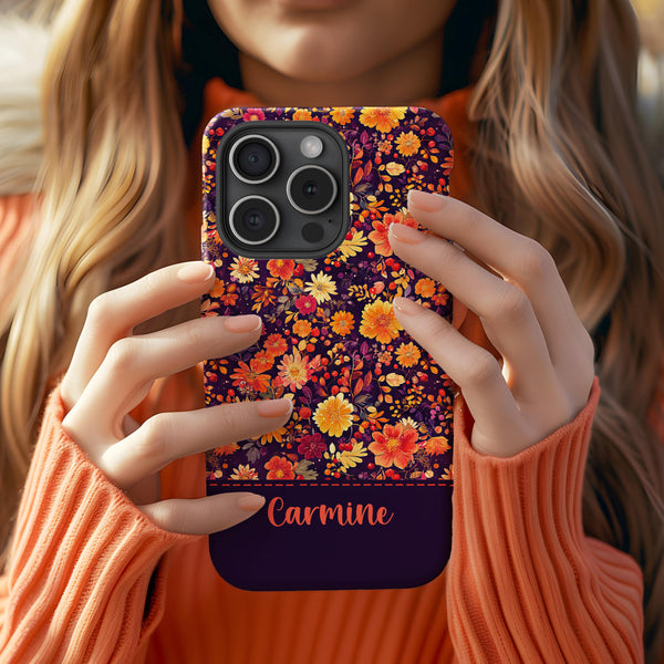 a woman holding up a phone case with flowers on it