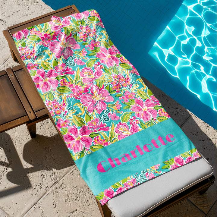 a beach towel sitting on top of a wooden bench next to a swimming pool