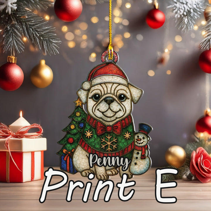 A Christmas ornament in the shape of a dog wearing a Santa hat and scarf, with a snowman and a gift box nearby. The ornament is hanging from a string, and there are red and gold ornaments and a lit candle in the background.