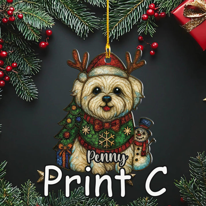 A Christmas ornament featuring a small dog wearing a Santa hat and scarf, with a snowman and presents, surrounded by pine branches and red berries.